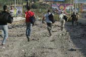 Lebanese civilians sprint past a bombed area Recalling Images of July 12, 2006