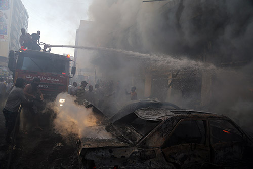 Fire fighters extinguish flames at the scene of the terrorist blast