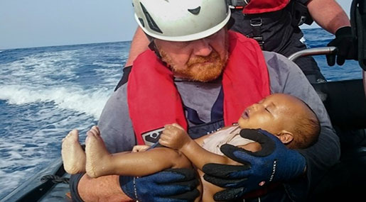 Drowned migrant Baby in the arms of a rescuer